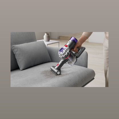 Dyson Car+Boat Handstaubsauger beim Reinigen eines Sofas