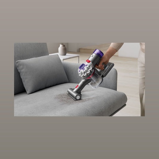Dyson Car+Boat Handstaubsauger beim Reinigen eines Sofas