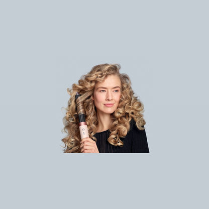 Frau mit gelocktem Haar hält den Dyson Airwrap Co-anda2x