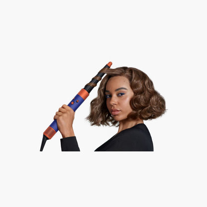 Frau stylt lockiges Haar mit dem Dyson Airwrap i.d.
