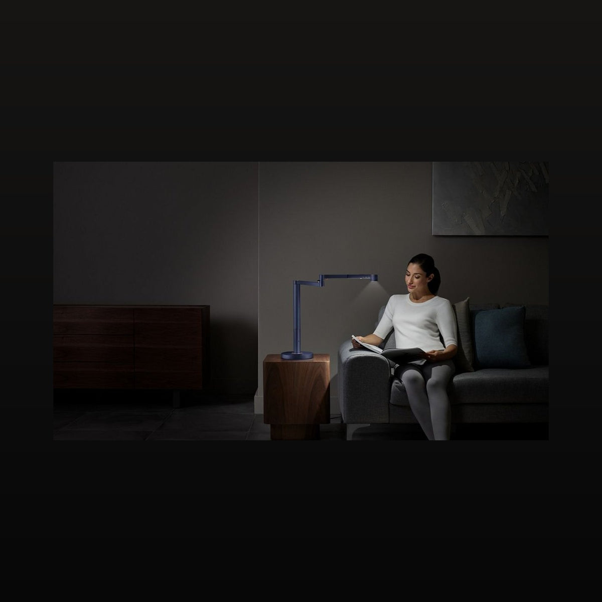 Frau liest bei Licht der Dyson Solarcycle Morph Tischleuchte