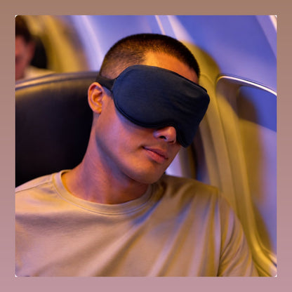 Mann trägt die SleepMask im Flugzeug