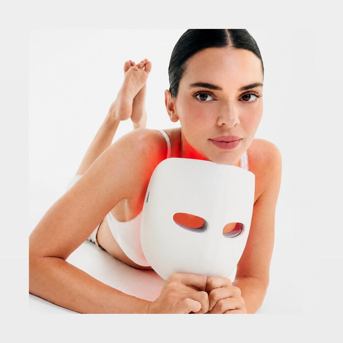 Frau hält die TheraFace Mask Glo in der Hand