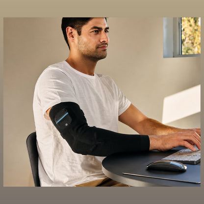 Mann trägt die RecoveryPulse Arm am Schreibtisch