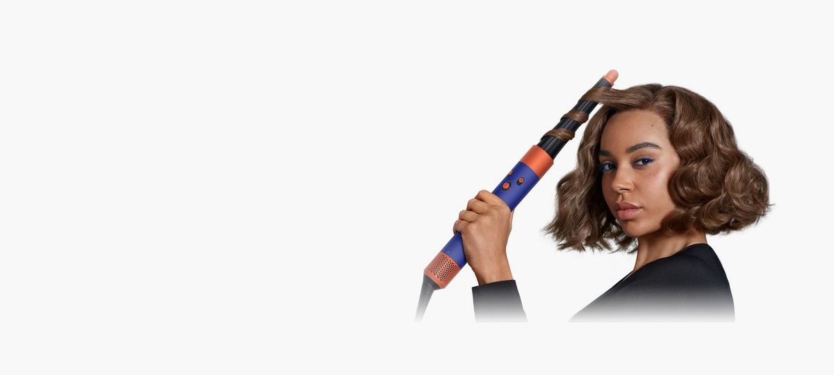 Frau stylt lockiges Haar mit dem Dyson Airwrap i.d. Multi-Haarstyler